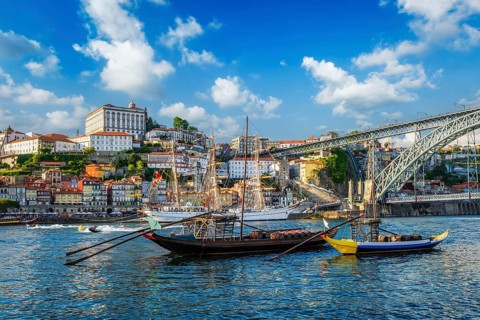 View of Porto city and Douro river with traditional boats with port wine barrels and sailing ship