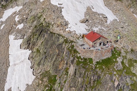 Aerial view of mountain hut Cabane de l'A Neuve, located on a steep rock formation, near La Fouly,