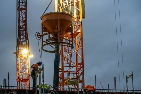 Concrete work, at dusk, on a large construction site building a residential and commercial complex,