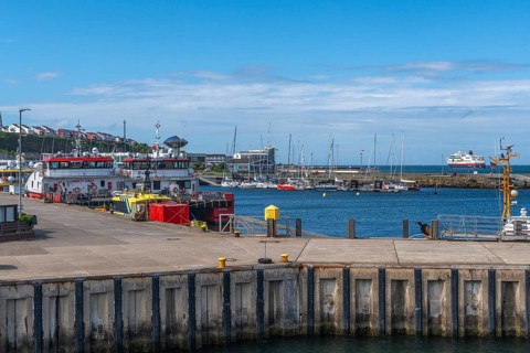Inland harbour with sailing yachts and offshore supply ships, pier, passenger ship MS Maud of