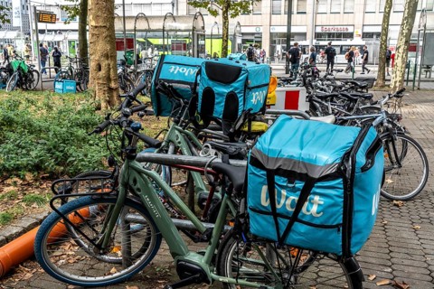 Wolt delivery service, parked bikes of bicycle couriers with thermal backpack, in front of the main