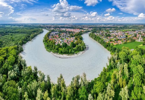 Loop of a river in the middle of lush nature with a small village and cloudy sky, Mühldorf am Inn