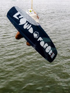 Young man with wakeboard at the jump start, water sports in the wakepark