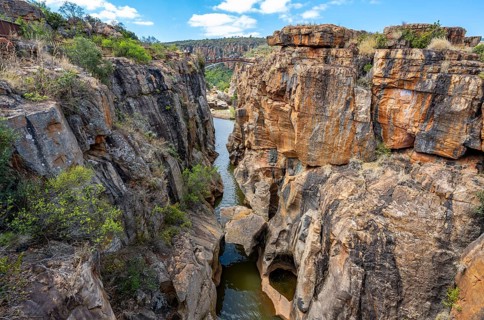 Bridge over a canyon with steep orange-coloured cliffs and the Blyde River, Bourke's Luck Potholes,