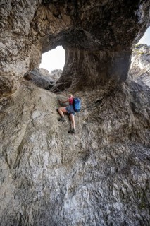 Hiker climbing through the Schindertor, Schinder, Tegernsee mountains in the Mangfall mountains,