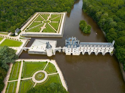 Aerial view of a French castle on the river Cher with neighbouring geometric castle park and green