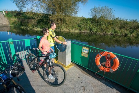 Cyclist, cycle tour, manually operated ferry across the Lippe near Halten am See, on the