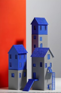 AI generated paper houses nestled against a seamlessly matching red and grey backdrop