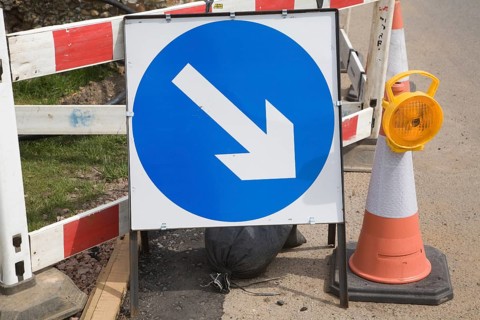 Blue direction arrow road sign at roadworks, Suffolk, England, United Kingdom, Europe