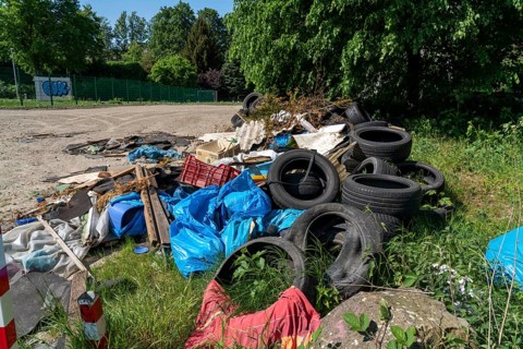 Illegally disposed waste, car tyres, building rubble, household waste, clothing, on a path next to