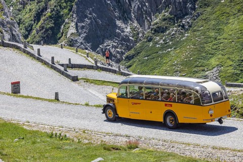 Historic postbus travelling along the Tremola, the world-famous serpentine road through the Val