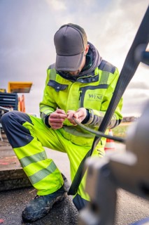 A worker in safety clothing doing manual work on a machine, glass fibre construction, Nagold, Black