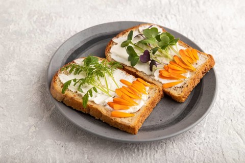 White bread sandwiches with cream cheese, calendula petals and microgreen radish and tagetes on