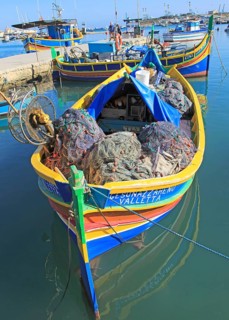 Colourful traditional fishing boats called luzzu in the harbour at Marsaxlokk, Malta, Europe
