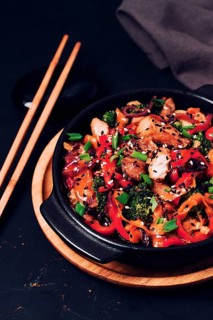 Asian cuisine, teriyaki meat with vegetables, in a cast-iron frying pan, close-up, no people
