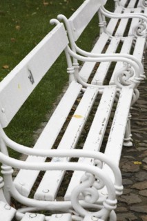 Old white painted wood and tubular steel sitting benches in a row, Prague Castle district, Prague,