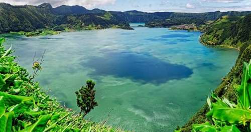 Calming view of the blue lake Lagoa Azul with the green hilly landscape under a clear sky, Lagoa