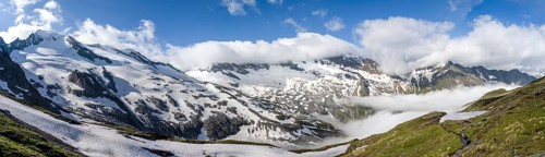 Mountaineer on hiking trail, mountain panorama with high fog in the valley, summit Hochfeiler,