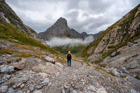 Mountaineers on a hiking trail with a view of rocky cloudy mountains and Wolayersee, hiking trail