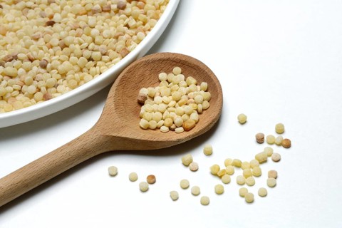 Fregola in wooden spoon, pasta variety from Sardinia, Italy, Europe