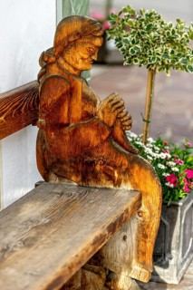 Wooden carved figure of an old woman, farmer's woman, board from the side of a typical bench,