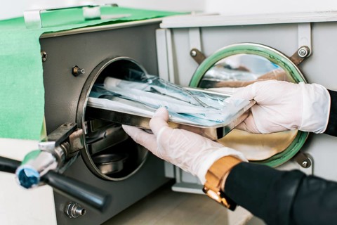 A dentist sterilizing his tools, Dentist with a dental sterilizer, A dentist with a dental