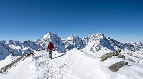 Ski tourers on foot, mountain panorama with snow-covered mountain landscape in winter, view of