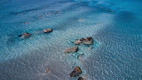 Crystal-clear sea water with visible stones and a calm atmosphere, Elafonissi, lagoon, south-west
