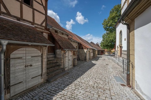 Inner courtyard with former so-called Kirchgaden, barns and St John's Church in the historic