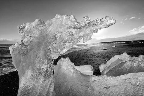 Backlit block of ice, b&w image, beach at glacier lagoon Jökulsarlon, Breiðamerkursandur, south