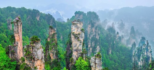 Famous tourist attraction of China, Zhangjiajie stone pillars cliff mountains in fog clouds at