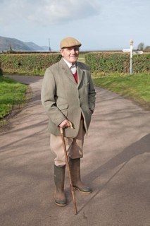 Smartly dressed gentleman out for his morning walk in Bossington, Exmoor national park, Somerset,