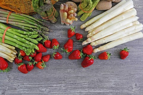 Green asparagus, white asparagus and fresh strawberries decorated on a rustic wooden table