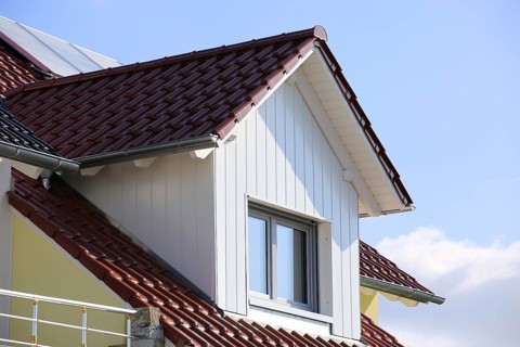 Large dormer window with wooden panelling on a tiled roof