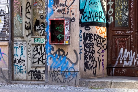 Defective chewing gum machine on a building in Berlin-Mitte, graffiti on the facade of a building.