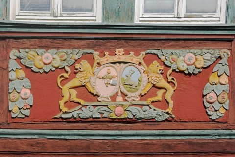 Wood carving of two yellow lion figures with crown at the house Zum goldenen Löwen, detail,