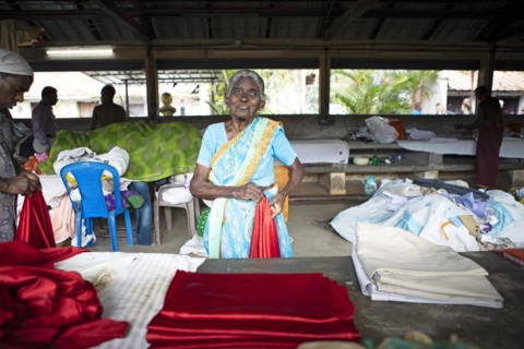 Indian woman folding laundry at Dhoby Khana laundry, Kochi, Kerala, India, Asia