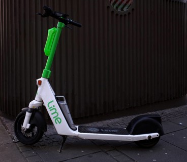 Electric scooter parked on the side of the road at the bike rental company Lime, OnLime and Uber,