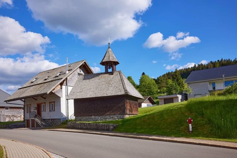 Chapel Unterlehen with road under blue sky with cumulus clouds in Bernau im Black Forest, Black