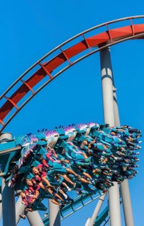 Theme park guests riding Dragon Challenge roller coaster in Wizarding World of Harry Potter at