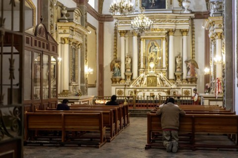 Oaxaca, Mexico, A man kneels in prayer in a Catholic church, Central America