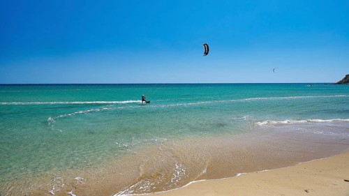 Kitesurfer rides on calm turquoise sea near the beach, surfer's paradise, kitesurfer, windsurfer,