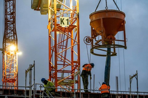 Concrete work, at dusk, on a large construction site building a residential and commercial complex,