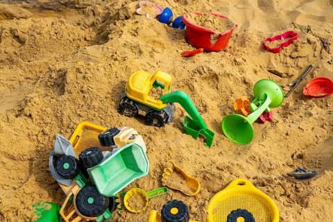 Sandpit, on a children's playground, sandpit with various plastic toys, excavator, shovels, moulds