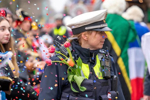 Rose Monday parade in Düsseldorf, policemen on duty at the street carnival, with flower