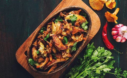Fried chanterelles with mushrooms, in a clay pan, close-up, top view, selective focus