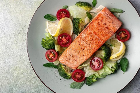 Grilled salmon fillet, with vegetables, broccoli, cherry, iceberg lettuce, spices and herbs,