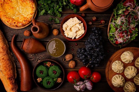 Traditional Georgian table, top view, Khinkali, Phali, Shoti, Khachapuri, Sauces, Fruits, nuts,