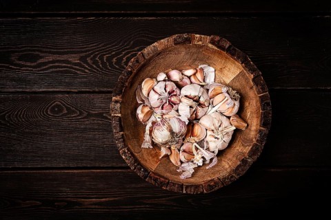 Fresh garlic, in a wooden plate, top view, close-up, no people