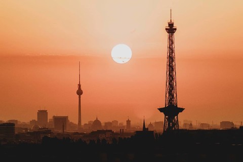 The sunrise emerges behind the city skyline with the television tower and the radio tower in